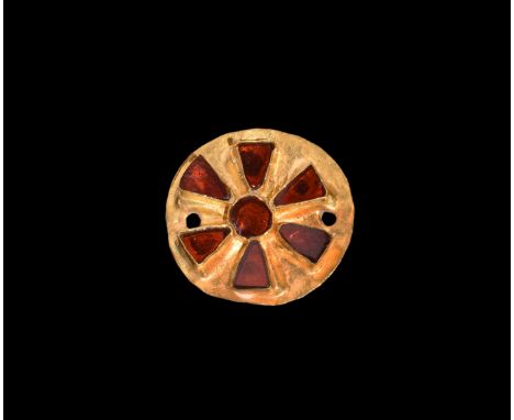 5th-6th century AD. A sheet gold disc with repoussé cells, a central roundel and radiating triangles each with an inset garne