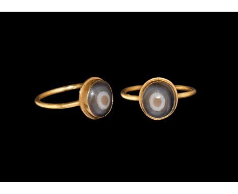 3rd-4th century AD. A gold finger ring with round-section hoop, discoid bezel with inset banded agate cabochon. Cf. Chadour, 