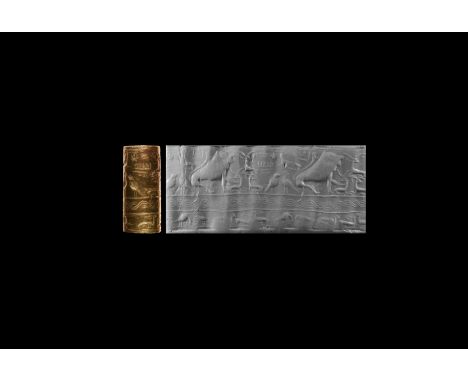 20th-16th century BC. A feldspar cylinder seal, the scene divided into three horizontal registers: in the upper a crouching l