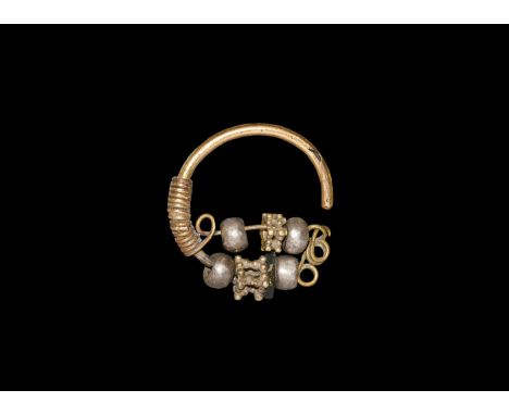 3rd-2nd century BC. A gold penannular rod with wire coiled to one end of the shank and passed in loops to the eye; four silve