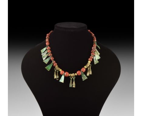 6th-9th century AD. A restrung necklace of red glass beads with six gilt glass beads framing coiled wire drum-shaped beads wi