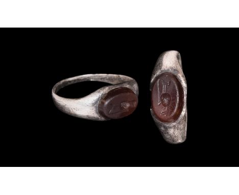 3rd century AD. A silver finger ring with tapering D-section hoop, plaque with inset carnelian cloison, intaglio ewer. Cf. Ru