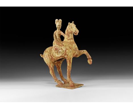 Tang Dynasty, 618-907 AD. A ceramic figurine of a horse and female rider on a rectangular base; the horse advancing with one 