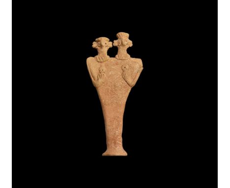 2nd-1st millennium BC. A ceramic figurine depicting a female with two heads; the eyes and breasts domed with round recesses, 