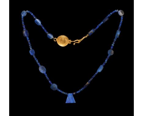 6th-7th century AD. A restrung necklace of small lapis lazuli beads with oval spacer beads between; to one end a fan-shaped l