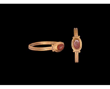 1st century BC-1st century AD. A gold finger ring comprising a slender hoop formed as two annulets of bead wire, ellipsoid be