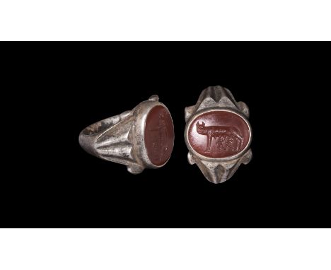 3rd century AD. A silver finger ring comprising D-section hoop and scooped shoulders with vertical ribbing, discoid bezel wit
