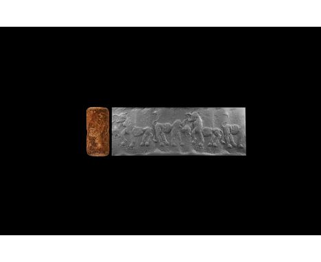 10th-8th century BC. A limestone cylinder seal with frieze of a lion with raised head and gaping jaws confronting a bull with