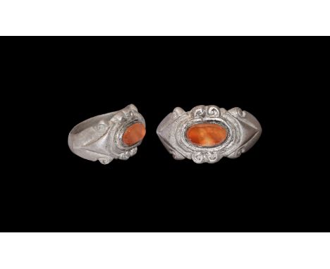 3rd century AD. A silver finger ring with D-section angled hoop, scrolled detailing to shoulders and ellipsoid bezel, stepped
