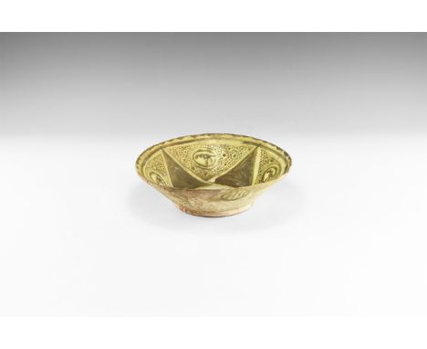 16th-17th century AD. A broad ceramic bowl with beige and yellow glaze, and panels of geometric design and triangles in a bro