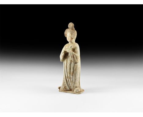 Tang Dynasty, 618-907 AD. A large ceramic figure of a plump courtly lady with elaborate hairstyle pulled up into buns at the 