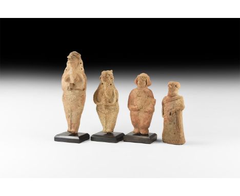 2nd millennium BC. A mixed group of ceramic statuettes comprising: two females each holding a drinking vessel to the midriff;