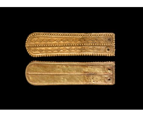7th-8th century AD. A hollow gold tongue-shaped strap end with gussetted sidewall, beaded wire panels to the reverse, beaded 