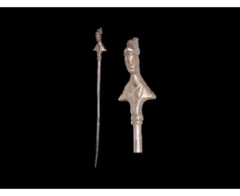 1st-2nd century AD. A silver dress pin with tapering shank, ribbed socle with bust of Minerva in crested helmet. 11 grams, 13