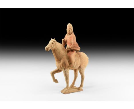 Tang Dynasty, 618-906 AD. A ceramic figure of a horse and rider; figure of male wearing a tunic and peaked headdress; horse w