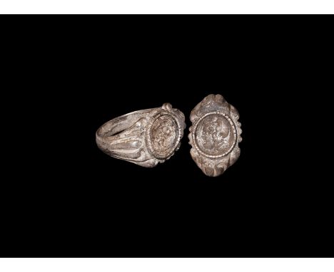 2nd-3rd century AD. A silver finger ring comprising a D-section hoop, flared shoulders with vertical ribbing, scrolled edge t