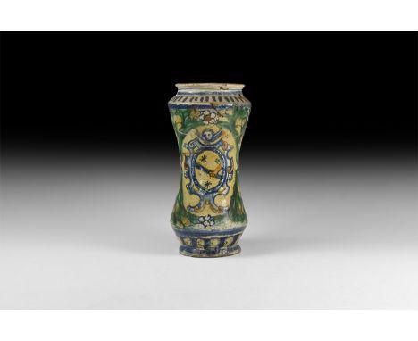 16th-17th century AD. A glazed ceramic apothecary's jar with waisted profile, polychrome design with floral swags and a heral
