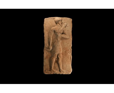19th-17th century BC. A rectangular ceramic plaque with a low relief standing male wearing a short skirt, long beard and a ha