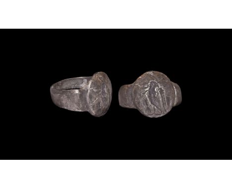 4th century AD. A silver finger ring comprising a tapering flat-section hoop, discoid bezel with convex panel, intaglio figur