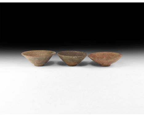Song Dynasty, 960-1127 AD. A group of three ceramic conical bowls with rim covered in a mottled dark glaze streaked with fine