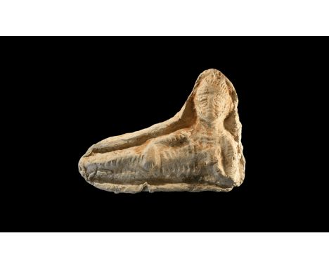 5th-3rd century BC. A ceramic plaque depicting a bearded male reclining, wearing a diadem, holding an item of food in his lef