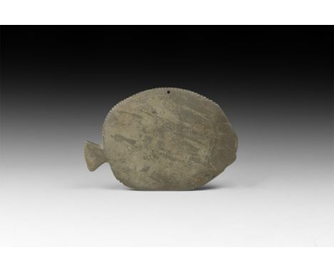 Predynastic, 4th millennium BC. A carved schist cosmetic palette formed as a fish with trapezoidal tail, dentilled upper edge