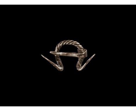 9th-11th century AD. A silver penannular brooch with twisted shank, splayed dragon-head terminals with punched pellet eyes, p