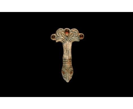 5th century AD. A silver-gilt bow brooch with three inset garnet cabochons to the headplate, broad bow with median rib, trans