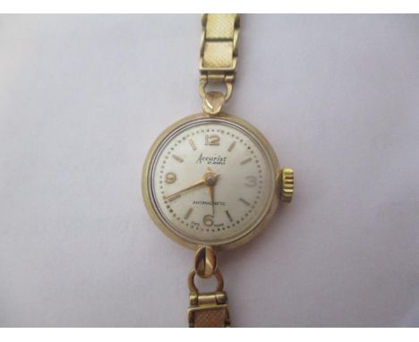 An Accurist 9ct gold ladies manual wind wristwatch. The dial having numerals and baton markers and having a 9ct gold strap, 1