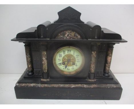 A Victorian black slate mantel clock of architectural form having an enamelled dial, gilt, pierced centre and fitted with an 
