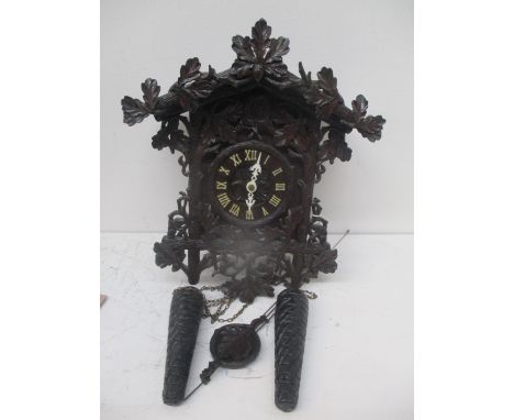 An early 20th century German Black Forest cuckoo clock having a floral design case, with applied ivorine Roman numerals, 15 1