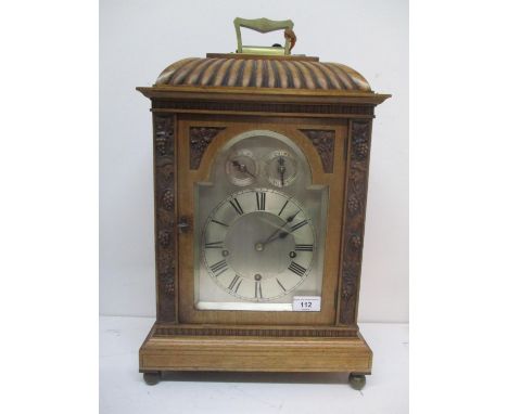 An early 20th century walnut cased bracket clock having a silvered arched top dial with Roman numerals, and two subsidiary di