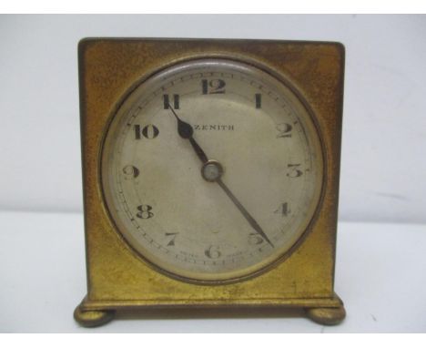 An early 20th century brass cased travelling bedside alarm clock. The dial having Arabic numerals and the movement numbered 1