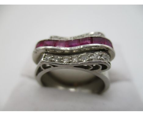 A white metal diamond and ruby dress ring having central step cut rubies bordered with two rows of brilliant cut diamonds, ri