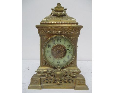 A late 19th century French ornate brass mantle/timepiece clock having twin carrying handles above embossed decoration and pie