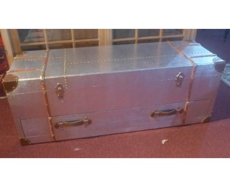 A contemporary aluminium aviator style low trunk with leather bound corners, H.45cm L.118cm W.40cm 