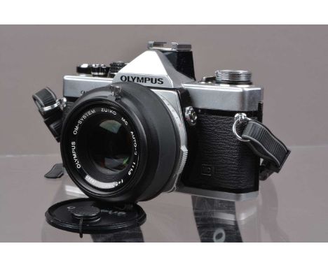 An Olympus OM-2n MD SLR Camera, shutter working, meter responsive, self timer working, responsive in auto mode, body G-VG, wi