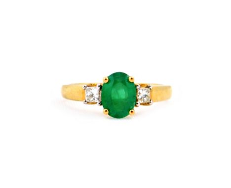 A 9ct gold, emerald and diamond three stone ring, centred with an oval mixed cut emerald approx. 1.20cts, claw set between sm