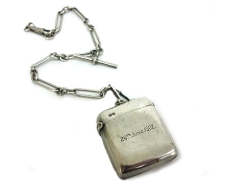 An Edwardian silver vesta case, Chester 1901, inscribed, to a silver watch chain with oval, circular and rectangular linking 
