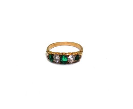 An Edwardian gold, emerald and diamond five stone ring with rose diamond points, the three graduated emerald-cut emeralds spa