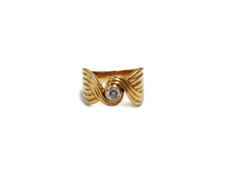 A Continental diamond solitaire ring, the round brilliant stone approx. 0.25cts, rub-over set within a swirling design, stamp