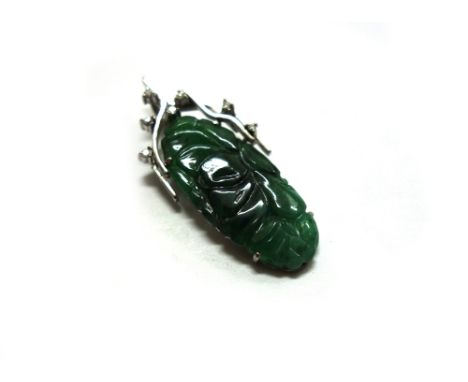 A Chinese jade and diamond pendant, the oval jadeite panel carved with fruit and leaves, measures approx. 28mm x 13mm, claw s