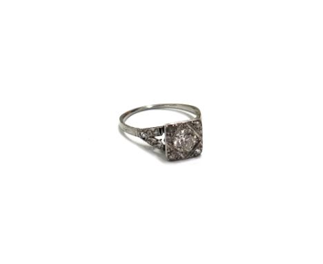 A mid-20th century platinum and diamond dress ring, the square head centred with a transition cut diamond, approx. 0.45cts, g