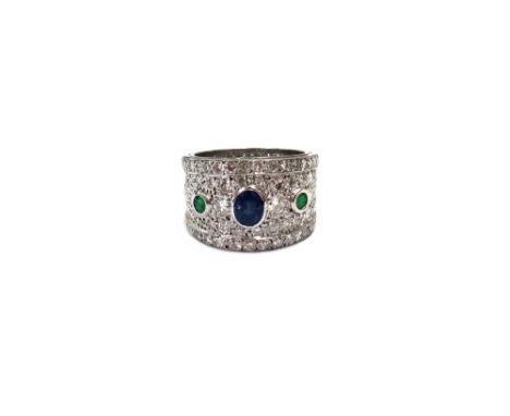 An emerald, sapphire and diamond broad band ring, the front rub-over set with an oval mixed cut sapphire, between two round m