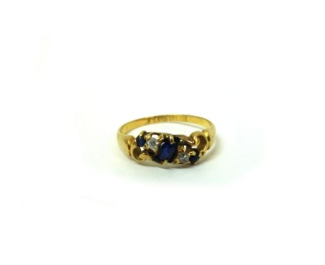 An 18ct gold five-stone sapphire and diamond ring, Birmingham 1902, in an asymmetrical scroll setting, size P 1/2, 2.7g gross