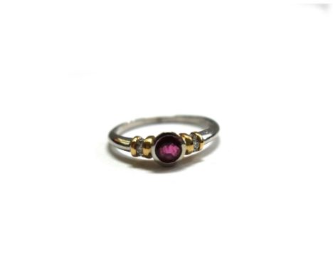 A modern 18ct gold ruby and diamond ring, centred with a round mixed-cut ruby approx. 0.35cts, rub-over set in white between 