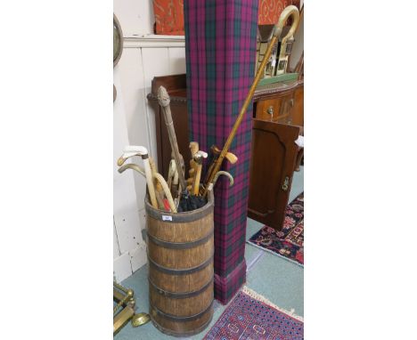 An oak coopered stick stand with various sticks and umbrellas Condition Report: Available upon request