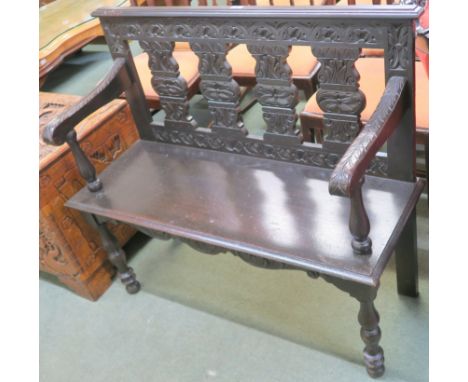 A stained oak hall bench with carved back and arms, 94cm high x 107cm wide x 40cm deep Condition Report: Available upon reque