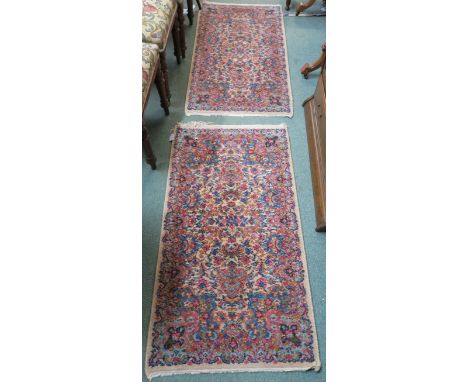 A pair of Karastan rugs with Kirman design, 123cm x 66cm (2) Condition Report: Fringes damaged, well used item with wear as p