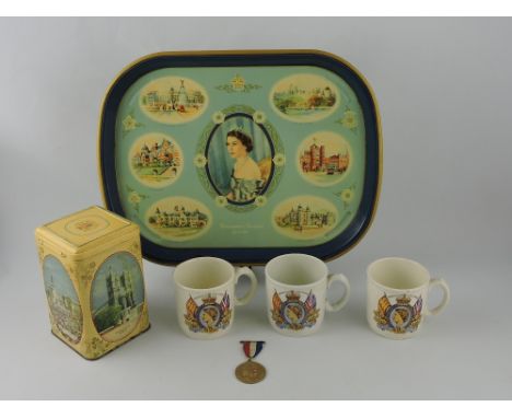 A collection of 1953 Coronation memorabilia including a tin tray, three mugs, a tea caddy and a presentation medal. (6)